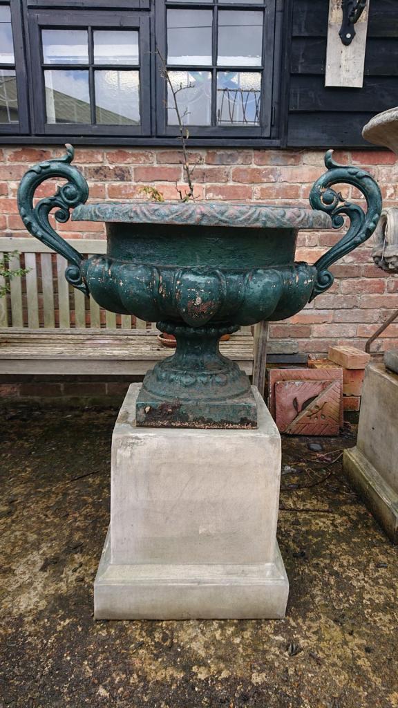 <p>Pair of French style cast iron urns on reconsituted stone plinths.</p>